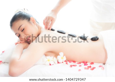 Portrait of beautiful young asian woman having enjoying and relax with massage and spa stone on  her back  in spa  beauty salon.