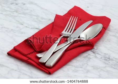 trendy and beautiful silverware set styled on linen double hemstitch napkin and antique carrara marble Royalty-Free Stock Photo #1404764888
