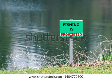 A sign prohibiting fishing in the pond.