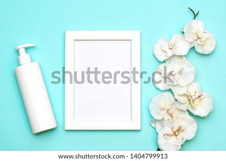 Blank white photo frame, body cream and white flower, self care and skin care concept. mockup