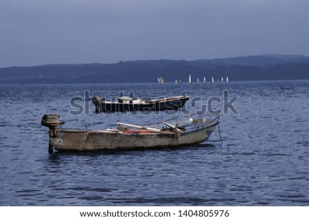 2 old fishing boats on the water. The symbol of loneliness and devastation. Boats are located on the lake. Evening hour