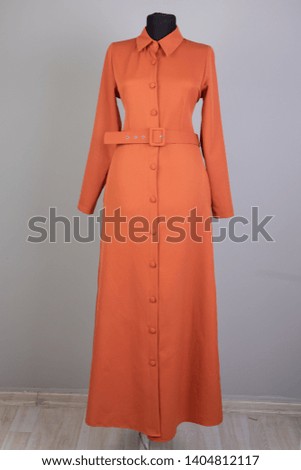 Woman in dress orange on gray backgound, veil