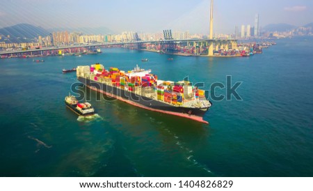 Aerial view drone photography Container Cargo freight ship with working crane bridge in shipyard under Stonecutters highway bridge at sunset for Logistic Import Export in Hong kong.