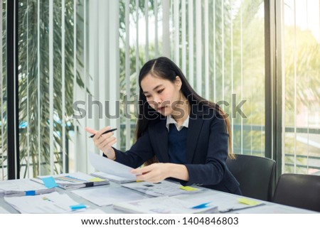 A businesswomen is holding a pen on his desk