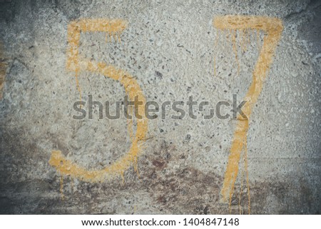 Yellow numbers on concrete wall