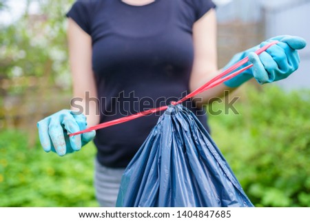 Picture of woman in rubber gloves with full gar in summer