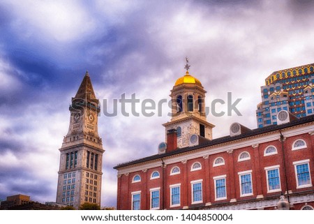 The custom house clock tower in the city of Boston Massachusetts cityscape on a cloudy blue sky day.