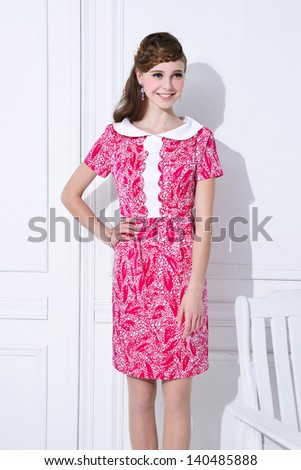 Beautiful young woman in red dress posing