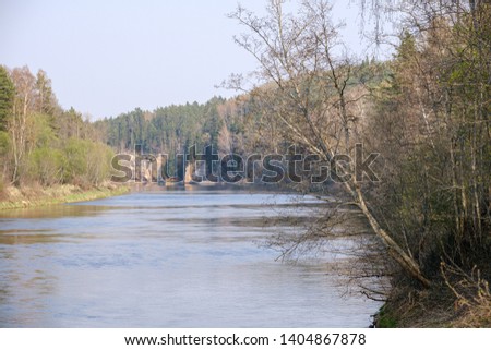 natural sand stone cliffs on the shore of the river in forest. Latvia