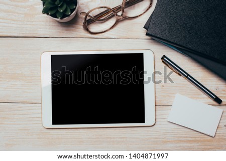 White digital tablet on wooden table. Flat lay.