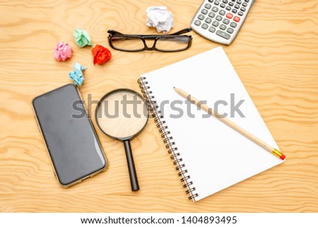 top view book , calculator, glasses on wooden table.