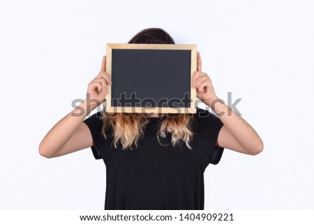 Portrait of young woman holding a chalkboard. 