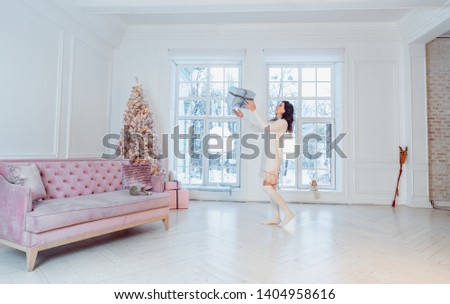 Beautiful young girl in white dress posing on camera. Christmas concept