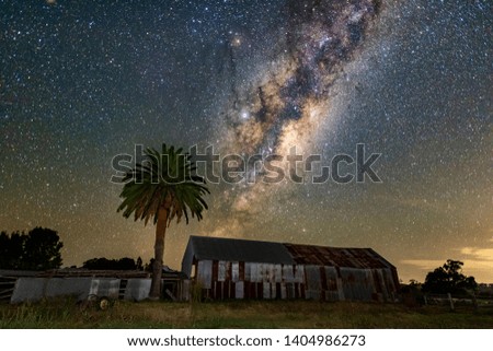 Milky Way rising next to farm shed and tree