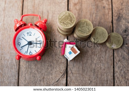 Coin ladder.Stacking coins on desk with clock. Finance and money concept.Stacked coins to save for the house with wooden table alarm clock, investment concept, finance, accounting and stock market.