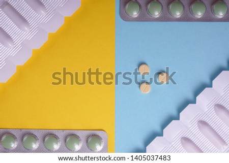 Pile of colorful pills & tablets on a colorful blue and yellow background. Drug prescription for a medication treatment. Pharmaceutical medication for health. Healthcare and pharmacy concept