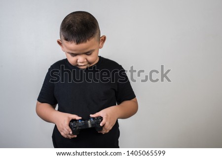 Happy boy play game computer with a controller in studio photo