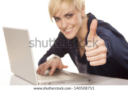 cute short hair smiling blonde working on a laptop and showing thumbs up with focus on the foreground on white background