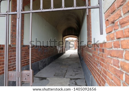 Old arch tunnel entrance gate to building inside 
