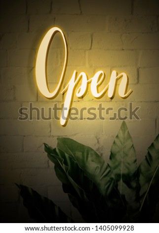 Neon yellow open sign on a brick wall