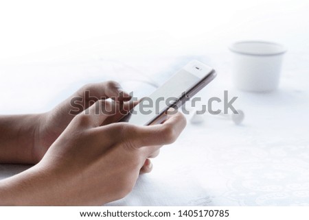 woman hang holding cellphone in relaxing morning breakfast with earphone and cup of coffee on white background