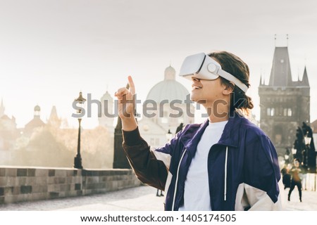 Woman wearing vr headset augmented virtual reality in history city center. Concept of virtual museum. Royalty-Free Stock Photo #1405174505