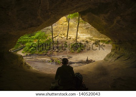 Hiker rests in natural cave