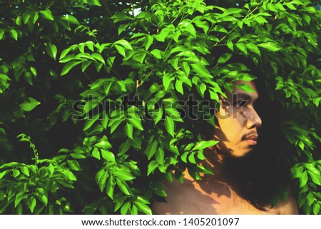 Handsome man with long hairstyle posing with plant with filter effect
