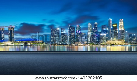 Side view asphalt road on night scene near the modern Singapore city . Royalty-Free Stock Photo #1405202105
