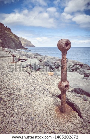 Old rusted piece of guard rail on a quay at Beach De Las Teresitas in San Andres, selective focus, color toning applied, Tenerife, Spain.