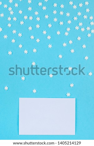 Creative Top view flat lay winter frame. Concept Mockup pattern made of small white snowflakes letter envelope pastel blue background copy space minimalism Template anniversary design invitation cards
