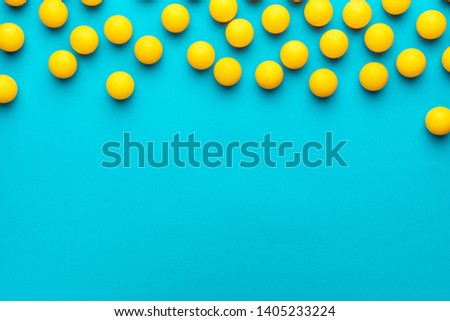 many balls for table tennis on turquoise blue background. flat lay image of many yellow table tennis balls with copy space. minimalist photo of yellow ping-pong equipment Royalty-Free Stock Photo #1405233224