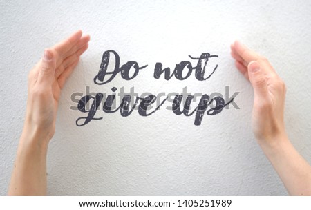 Female hands enclosing text "Do not give up", motivational message