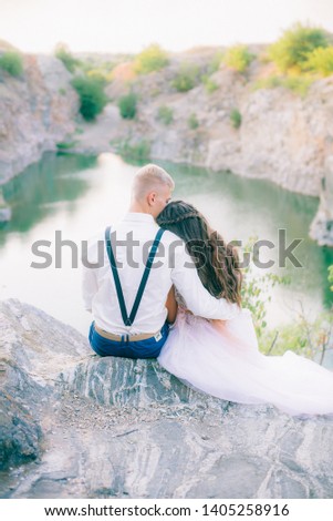 Elegant gentle stylish groom and bride near river or lake. Wedding couple in love 
