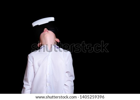 Young boy with glasses of virtual reality looks up. White shirt. Black background