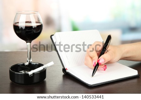 Hand signing in notebook, on bright background
