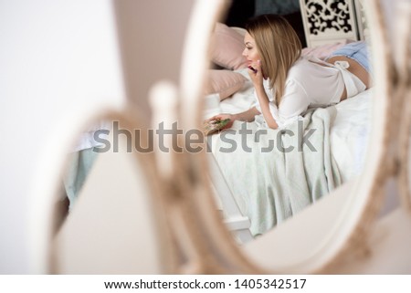 girl painter on the bed in her room admires the picture she drew