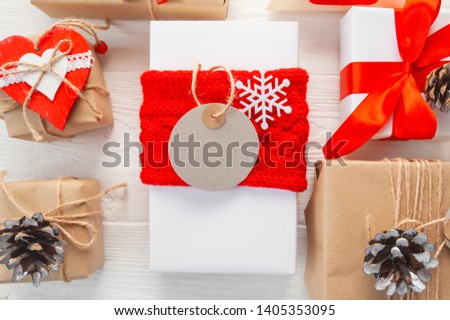 mockup Christmas kraft gift boxes with tag on wooden background. Top view for xmas greeting card