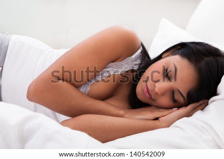 Portrait Of Young Woman Sleeping On Bed