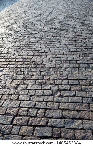 Stone paving stone in the light of the sunrise in Prague