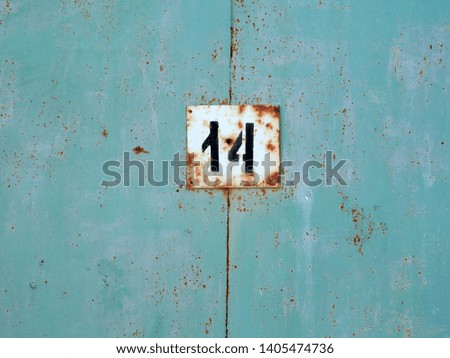 
The number fourteen on a metal plate.					