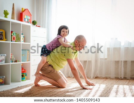 Father plays at home with his cute little daughter. 