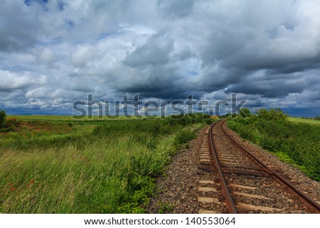 Railroad in rural area, with storm clouds on the horizon