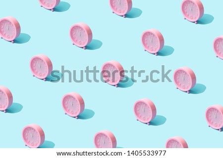 Trendy sunlight Summer pattern made with pink clock on bright li Royalty-Free Stock Photo #1405533977