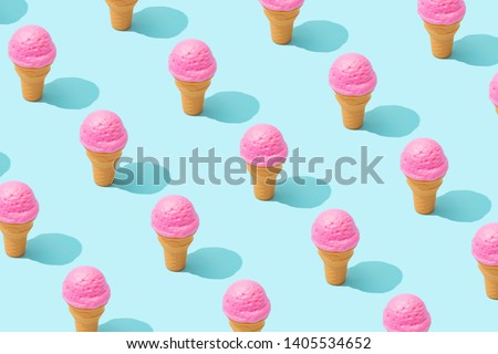 Trendy sunlight Summer pattern made with pink strawberry ice cream on bright light blue background. Minimal summer concept.