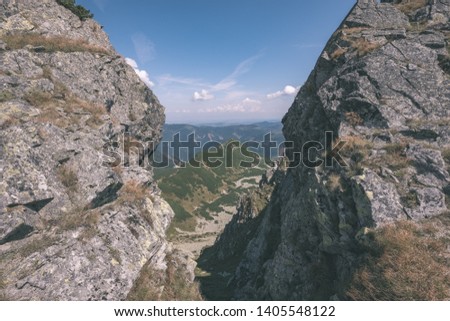 rocky mountain tops with hiking trails in autumn in Slovakian Tatra western Carpathian with blue sky. Empty rocks in bright daylight, far horizon for adventures. - vintage old film look