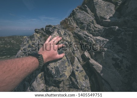rocky mountain tops with hiking trails in autumn in Slovakian Tatra western Carpathian with blue sky and late grass on  hills. tourist hand holding by rock - vintage old film look