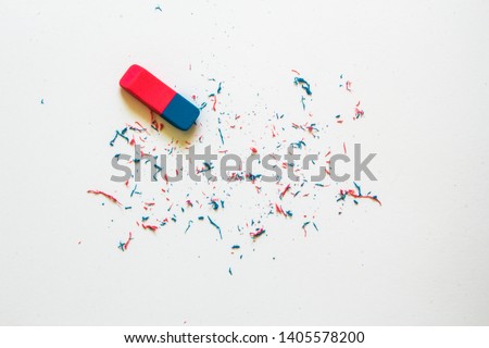 Pink and blue eraser and it’s shavings sitting on a clean white sheet of paper with copy space – Small office supply for correcting errors – Concept image for erasing mistakes and editing Royalty-Free Stock Photo #1405578200