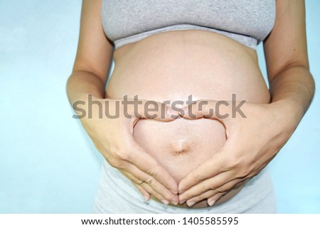 
Picture women are pregnant
Gestational age of about 6-9 months
Appearance near birth And she uses both her hands to make a heart shape, expressing her mother's love
Around the belly around the navel.