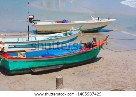 Old wooden fishing boat on white beach.